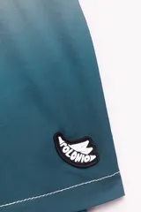 Short de baño con degradé de color beige a azul, con cintura elástica y cordón ajustable. Tiene protección UV50, logo de la marca, dos bolsillos laterales y uno trasero con cierre.