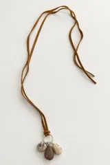 Collar de diseño artesanal compuesto por un cordón de cuero tostado ajustable y un dije con anilla metálica del que cuelgan tres piedras naturales.