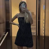 Vestido negro con estampado de ondas plateadas y tirantes de cadena metálica.