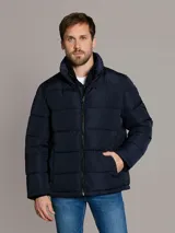 Campera puffer azul marino de Calvin Klein, de diseño acolchado con cuello alto y cierre frontal de cremallera. Incluye bolsillos laterales con cierre y chaleco interior desmontable.