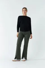 Sweater negro de punto liviano con textura acanalada y diseño de hombros caídos.