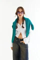 Top de manga larga color amarillo, confeccionado en tejido acanalado con cierre frontal de botones a presión metálicos. Presenta detalles de botones en los puños y un corte ajustado al cuerpo.