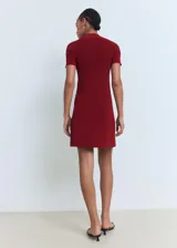 Vestido corto de tejido de punto fino en color bordó, con cuello perkins y mangas cortas. Presenta un diseño evasé que se ajusta suavemente al cuerpo.