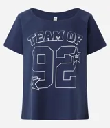 Remera de algodón azul marino con cuello redondo y manga corta. Presenta un estampado frontal en blanco con el texto "TEAM OF" y el número "92" en tipografía deportiva, rodeado de estrellas.