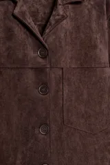 Sobrecamisa de tejido efecto ante en color marrón, con cuello solapa, manga larga con puños y cierre frontal de botones. Presenta un bolsillo de plastrón en el pecho.