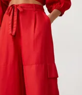 Pantalón acampanado de viscosa color rojo, con trabillas en la cintura, lazo y bolsillos cargo laterales.