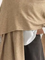 Ruana de tejido de punto trenzado en color crudo, con diseño abierto, corte holgado y mangas amplias tipo kimono.