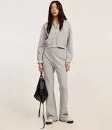 Saco color crema, de corte slim, confeccionado en algodón con viscosa certificada, con cuello con capucha y cordón ajustable, cierre frontal con cremallera y forro de fleece.