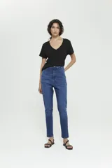 Pantalón jean azul de tiro caído, calce confort, pierna angosta en tobillo, detalles en bolsillos y canesú trasero. Lavado stone con bigotes y leve localizado.