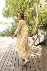 Vestido camisero con estampado floral en tonos celeste y blanco, cuello a la base, manga al codo y botones al frente.