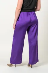 Pantalón palazzo rojo de satén con cintura elastizada y bolsillos laterales.