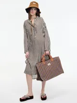 Vestido largo de manga larga con botones en el escote y tajos verticales laterales. Diseño a rayas verticales en tonos marrón y blanco.