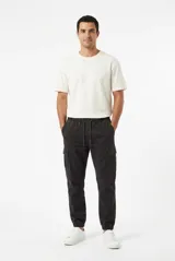 Pantalón jogger cargo color gris oscuro, con cintura elástica con cordón de ajuste, bolsillos laterales en las piernas y puños elásticos en los tobillos.