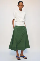 Falda midi de tiro alto, confeccionada en hilatura con mezcla de viscosa, con diseño de rayas verticales en tonos verdes y negros. Presenta corte evasé con bajo acabado y cierre con cremallera oculta en la costura.