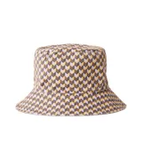 Sombrero tipo bucket reversible de Rip Curl. Un lado presenta un estampado geométrico en tonos marrón, amarillo y lavanda. El reverso es de color lila liso.