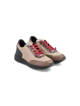 Championes urbanos con diseño de paneles en tonos beige, marrón y negro, con cordones en color rojo intenso y suela de plataforma negra.