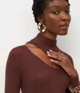 Blusa de punto acanalado color lila, con cuello alto, mangas largas y abertura en el hombro.