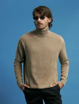 Polera de punto de manga larga en color azul marino, con cuello alto doblado y puños y ruedo acanalados.