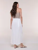Falda larga de color blanco con pretina elastizada y fruncidos en la cintura, con caída holgada y ligera.