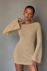 Vestido corto de punto color beige, con escote bote y mangas largas acampanadas.