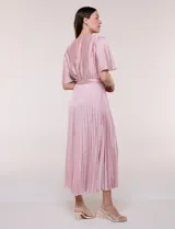 Vestido maxi de satén color rosado, con escote en V cruzado, mangas cortas amplias, cintura elastizada con lazo de ajuste y falda plisada con forro interno.