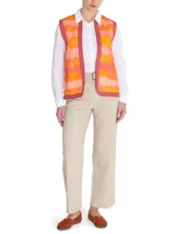 Chaleco sin mangas estilo boho, con estampado de ondas en tonos naranja, rosado y amarillo. Presenta bordes con detalles geométricos en color bordó y cierre frontal abierto.