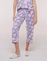 Pijama compuesto por remera sin mangas con escote redondo, botones frontales y detalle de puntilla, acompañado de un pantalón capri con cintura elástica. Presenta un estampado floral en tonos rosados sobre base gris.