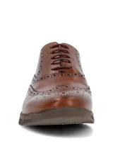 Zapato tipo Oxford estilo brogue color marrón, con detalles de perforaciones decorativas en la puntera y laterales. Cuenta con cierre de cordones y suela de goma con diseño deportivo.