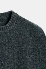 Chaleco de lana 100% color gris oscuro, con cuello redondo, manga sisa amplia y acabados en rib.