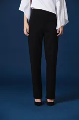 Pantalón de vestir negro de corte recto y tiro alto, con costura central vertical en cada pierna y silueta fluida.