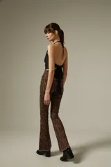 Pantalon de jean con corte flare y tiro alto, estampado con diseño animal print de leopardo en tonos marrones. Cuenta con bolsillos funcionales y ruedo desflecado.