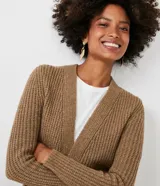 Cardigan largo de punto abierto, color marrón tostado, con mangas largas y dos bolsillos delanteros aplicados. Presenta una textura acanalada y diseño sin cierre.