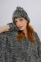 Ruana artesanal tejida en telar manual, con diseño jaspeado en tonos negro y crudo. Presenta una textura rústica y terminación con flecos en el ruedo, además de una etiqueta de cuero con la marca Pura Lana.