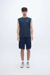 Musculosa azul marino con cuello redondo y sisas amplias. Presenta un pequeño estampado en el pecho con texto en blanco.