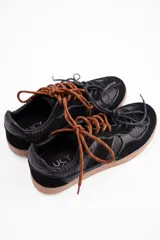 Championes de cuero vacuno color marrón, con diseño de doble cordón en tonos contrastantes y suela de goma al tono.