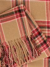 Bufanda de tejido suave con diseño de cuadros escoceses en tonos marrón, rojo, negro y blanco, terminada con flecos en los extremos.