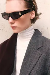 Blazer de mujer gris oscuro con estampado Príncipe de Gales (a cuadros). Presenta solapas de muesca, cierre frontal de dos botones, hombreras y bolsillos delanteros con solapa.