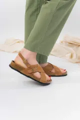 Sandalias de cuero marrón con tiras cruzadas, base de corcho y suela antideslizante.
