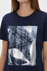 Remera de manga corta de algodón en color blanco, con cuello redondo y diseño holgado. Cuenta con un estampado frontal central con detalles metalizados estilo foil.