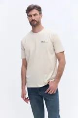 Remera de manga corta color beige, con cuello redondo y estampado de lettering en el pecho.