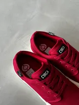 Championes de lona color bordó con suela blanca, de corte bajo y cierre con cordones.