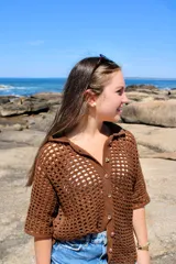 Camisa marrón tejida a crochet con hilo de algodón, de mangas cortas y cuello camisero.