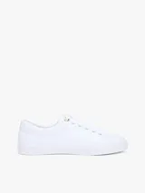Zapatillas Tommy Hilfiger modelo Lulu Gold, de color blanco y diseño de corte bajo. Están confeccionadas en capellada sintética con cordones blancos, ojetes metálicos dorados y forro interno de algodón. Presentan detalles distintivos de la marca y monograma TH en el lateral.