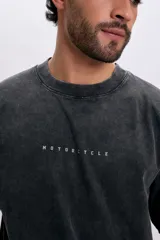 Remera de manga corta con efecto acid wash en color gris oscuro, de corte holgado y estampa trasera con la leyenda "Hardcore Rider" en tipografía gótica.