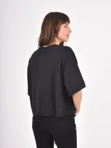 Remera negra de corte holgado con estampa frontal de línea abstracta en color blanco.