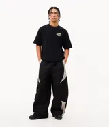 Pantalón barrel de poliéster color negro con recortes contrastantes en tono gris claro en los laterales, de corte amplio y urbano con cintura elástica.