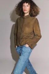 Jeans de tiro medio con corte bootcut, confeccionados en denim azul con efecto lavado y ligeros desgastes. Presentan diseño de cinco bolsillos, trabillas en la cintura y cierre frontal con cremallera y botón.