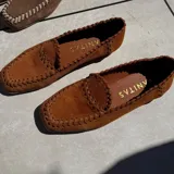 Mocasines color marrón cuero, de cuero vacuno, con punta cuadrada y detalle de tientos de cuero pasados a mano.