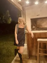 Minivestido negro de terciopelo con detalles brillantes y apliques de tela bordada en los hombros.