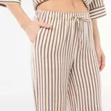 Pantalón de lino con dos bolsillos, corte ancho y diseño a rayas multicolor.